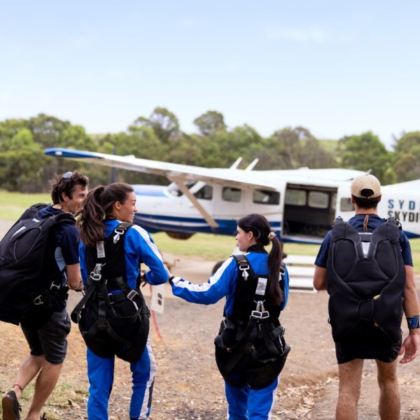 Group of friends walking towards sky diving plane. Image Credit - Destination NSW