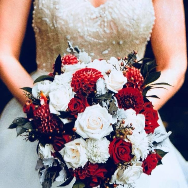 Bride holding bouquet of red and white flowers