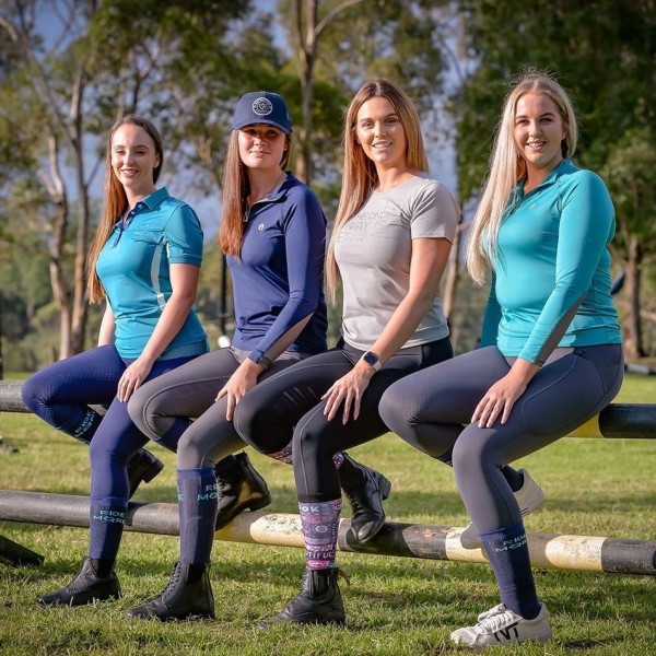 Four ladies sitting on fence modelling horse riding wear