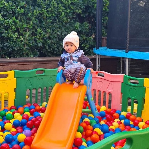 Child at the top of the ball pit slide
